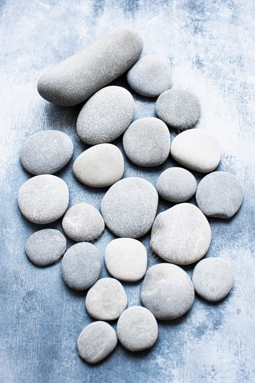 Preview: A serene arrangement of smooth stones on a textured blue background
