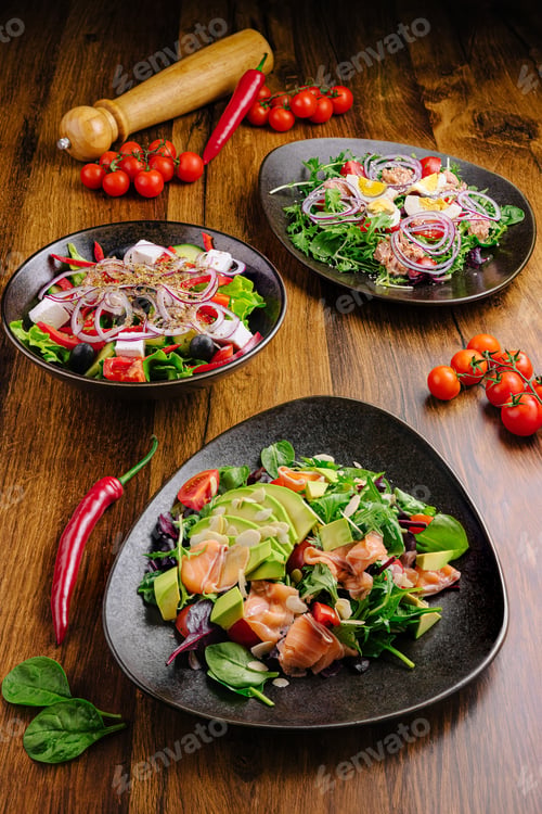 Preview: Colorful gourmet salads displayed on wooden table with fresh ingredients