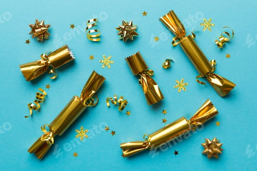 Preview: Christmas crackers with shiny confetti on color background, top view, copy space
