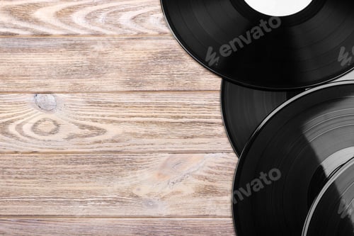 Preview: Black vinyl records on the wooden table, selective focus with copy space. Top view