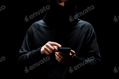 Preview: cropped view of hacker pointing with finger at smartphone isolated on black