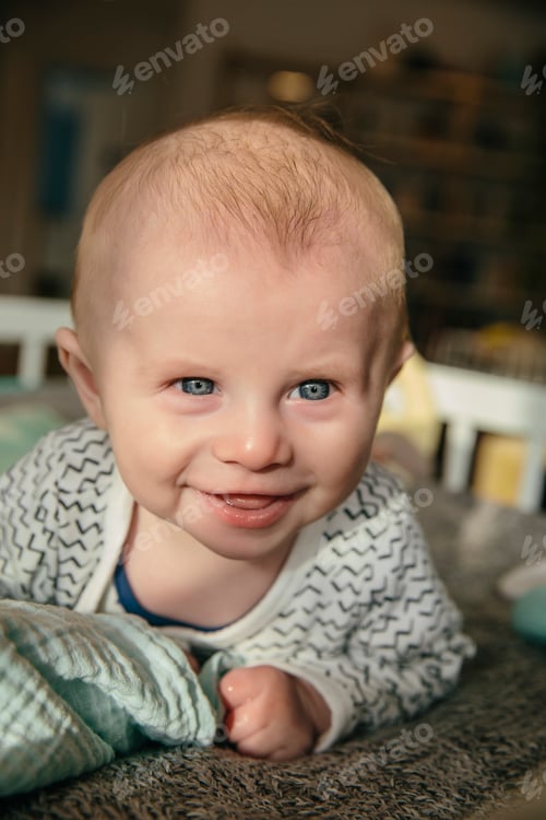 Preview: Happy three-month-old baby looking up and smiling at something in his crib
