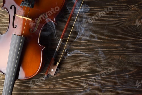 Preview: Violin with bow on brown wooden table.