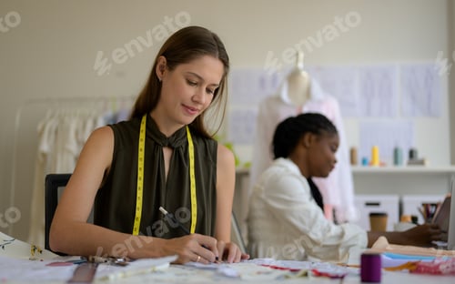Preview: Happy female dressmaker working in workshop studio