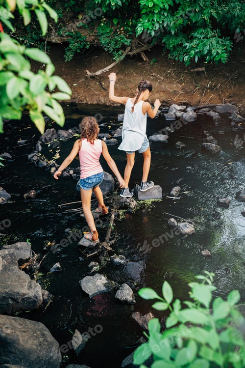 Preview: Girls using stones to cross creek