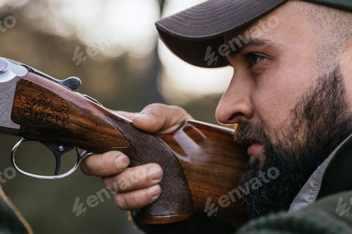Preview: Man Aiming a Shotgun Outdoors in Natural Setting
