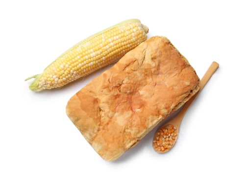 Preview: Freshly baked cornbread loaf, seeds and cob isolated on white, top view