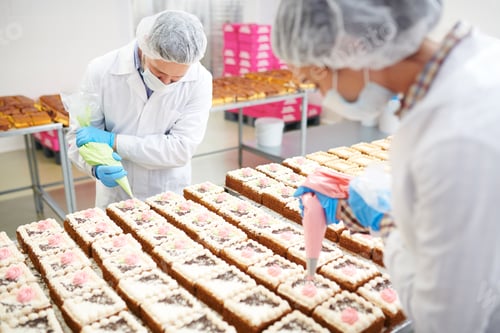 Preview: Confectioners decorating cakes with cream