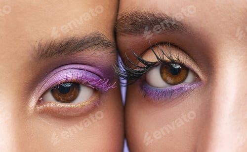 Preview: Cropped shot of two young women wearing purple make-up