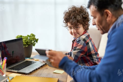 Preview: Little hispanic school boy doing homework together with his father
