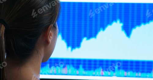 Preview: Woman look at the stock market data on computer monitor