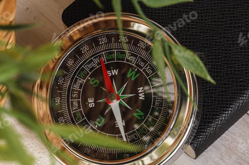 Preview: Compass surrounded by mountain gear tools on wooden background