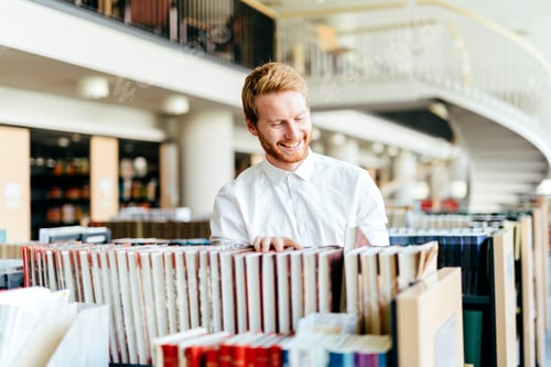 Preview: Handsome student searching for a book in a library