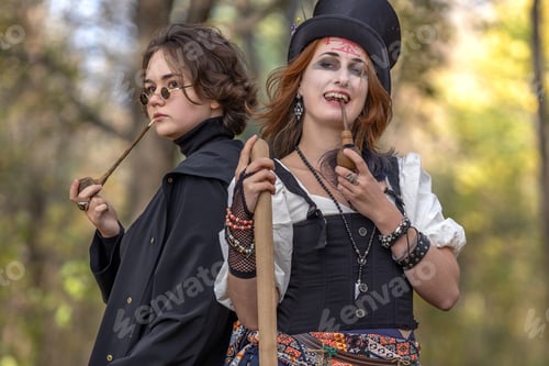 Preview: Portrait of young women in Halloween carnival costume in autumn park.