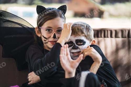 Preview: Cute little sister and brother wearing Halloween costumes and scaring each other