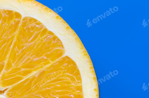 Preview: Top view of a one orange fruit slice on bright background in blue color