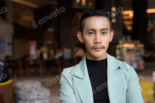 Preview: Portrait of nonbinary genderfluid young Asian gay man in cafe
