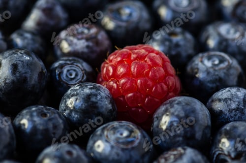 Preview: Fresh raspberries among blueberries close-up, fresh berries, summer season, natural background.