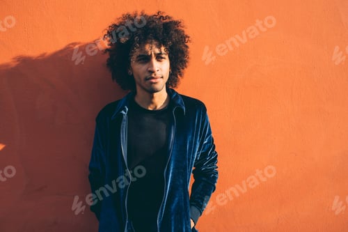 Preview: Portrait of young man against orange coloured wall