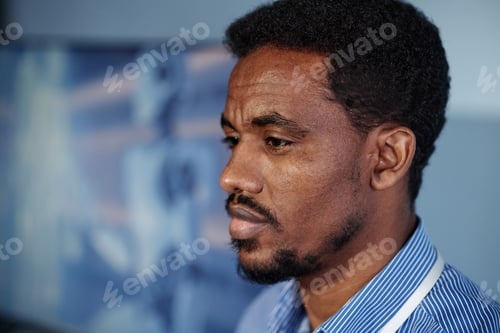 Preview: Black Man Presenting Research Results at Technology Conference in Auditorium