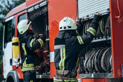 Preview: firefighters in protective uniform checking equipment in truck on street
