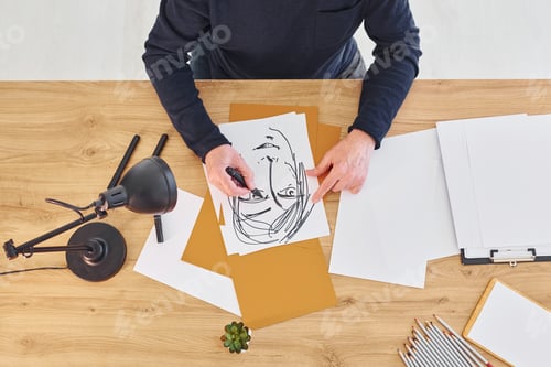 Preview: Top view of painter that working on the sketch of a man