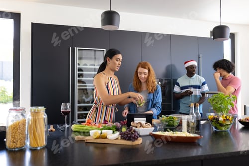 Preview: Happy diverse friends with santa hat cooking at christmas