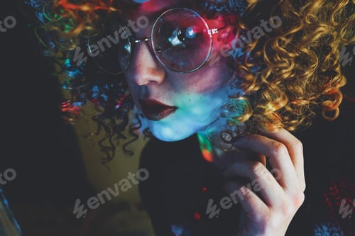 Preview: Young woman portrait illuminated by psychedelic lights
