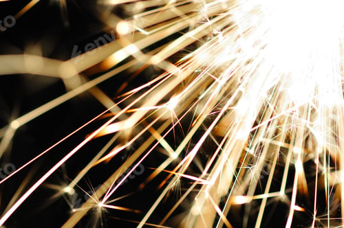 Preview: Close-up of golden blurry sparks burn in the dark