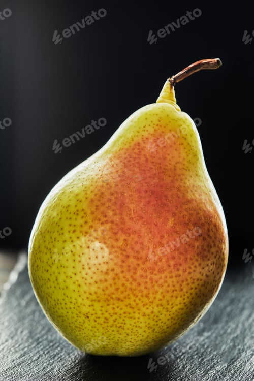 Preview: Fresh pear on black stone on wooden background
