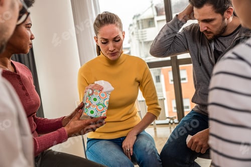 Preview: Diverse group of people sitting in circle in group therapy session.