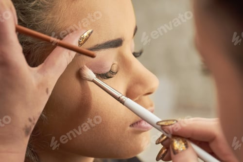 Preview: Hand of visagist applying eyeshadow