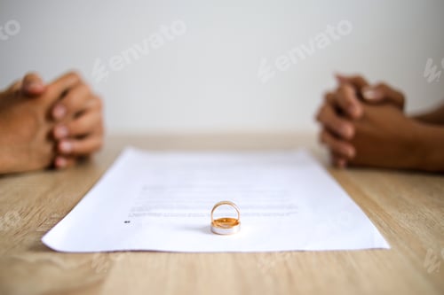 Preview: Selective Focus of Wedding Rings on Top of Contract Decree of Divorce