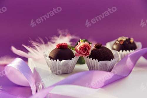 Preview: Chocolate decorated candies. Trendy pink feathers. Purple very peri pantone color pattern.