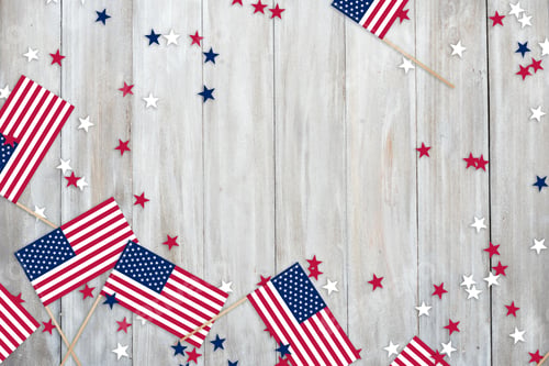 Preview: USA Independence Day July 4th. Mini USA flags and confetti stars on a wooden shabby background with