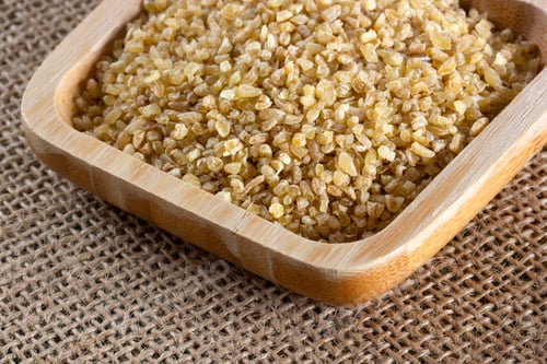 Preview: raw wheat grains in wooden plate
