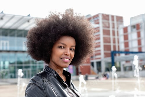 Preview: Young woman with afro hair on city concourse, portrait