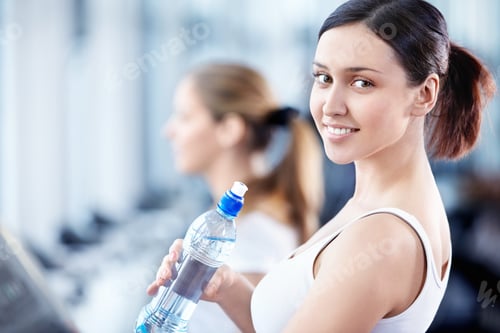 Preview: Smiling Woman Holding Water Bottle at the Gym