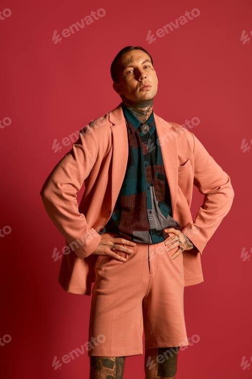 Preview: Stylish young man showcasing modern fashion in a vibrant studio setting