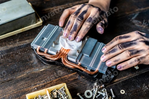Preview: computer repair master with dark dirty hands cleaning the electronic piece on the table f
