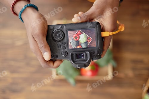 Preview: Young Adult Man Photographing Fresh Vegetables with Professional Camera
