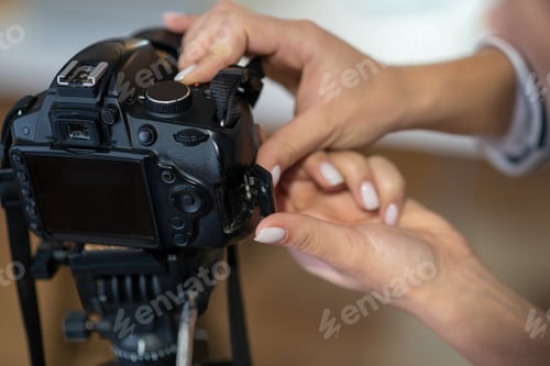 Preview: Close up of female hands setting up the camera