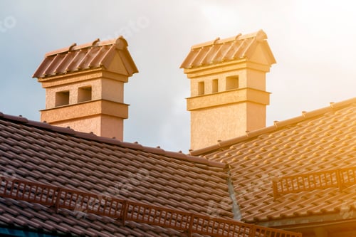 Preview: Top of new big spacious modern house with shingled red roof, two high chimneys, plastered walls and