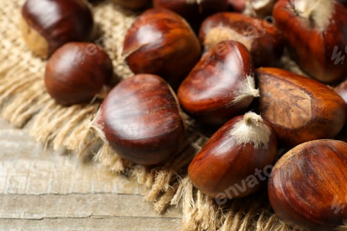 Preview: Fresh sweet edible chestnuts on wooden table, closeup