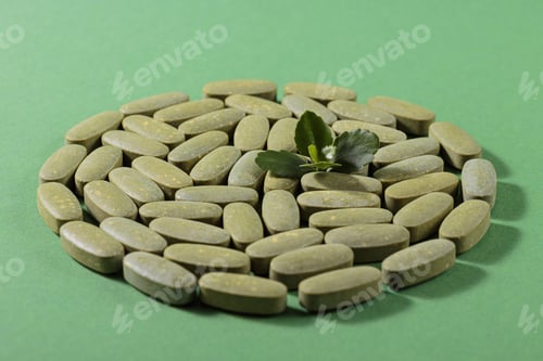 Preview: Herbal and Vitamin Green pills laid on green background