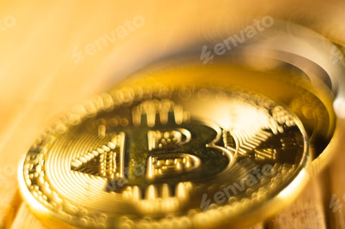 Preview: Closeup shot of gold and silver bitcoins scattered on a surface illuminated with bright light