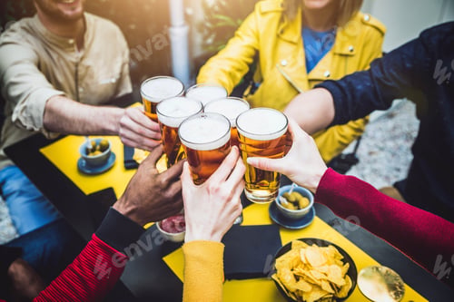 Preview: Group of multicultural friends drinking and toasting beer at brewery bar restaurant -