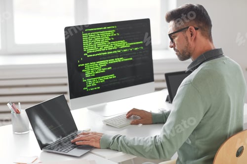 Preview: Programmer working on desktop computer