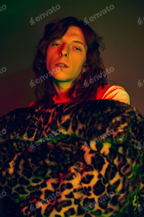 Preview: Stylish young man exudes confidence and trendsetting flair in vibrant, artistic lighting
