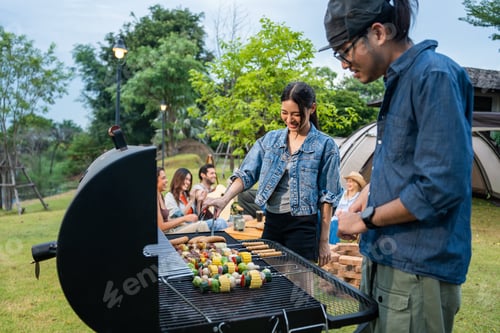 Preview: Group of diverse friend having outdoors camping party together in tent.